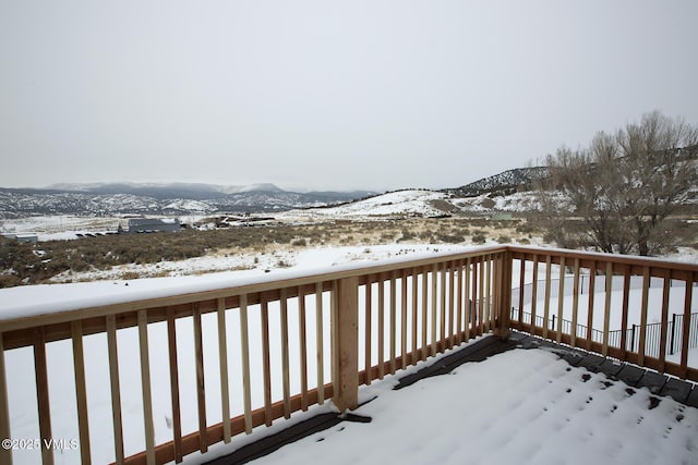 snow covered deck featuring a mountain view