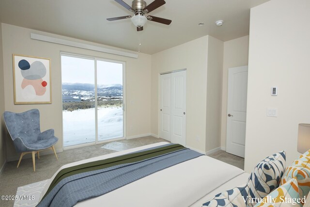 carpeted bedroom with ceiling fan, access to exterior, a mountain view, and a closet