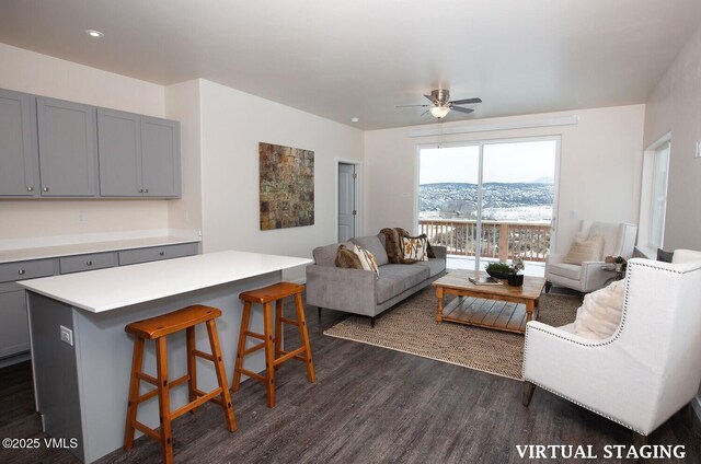 living room featuring ceiling fan, dark hardwood / wood-style floors, and a mountain view