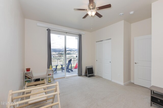 interior space featuring carpet, a ceiling fan, access to outside, and baseboards
