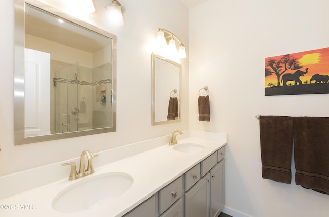 full bathroom featuring a stall shower, double vanity, and a sink