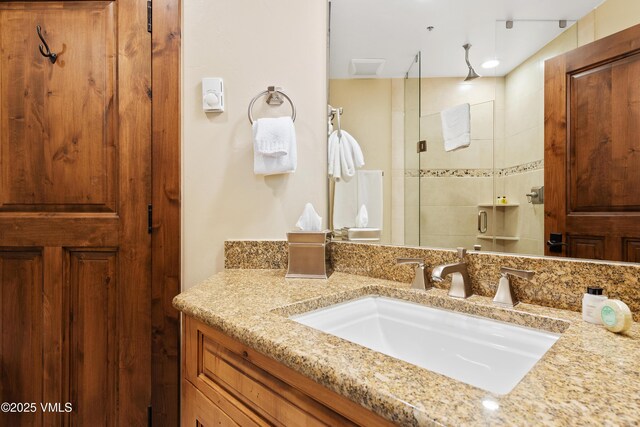 bathroom featuring an enclosed shower and vanity