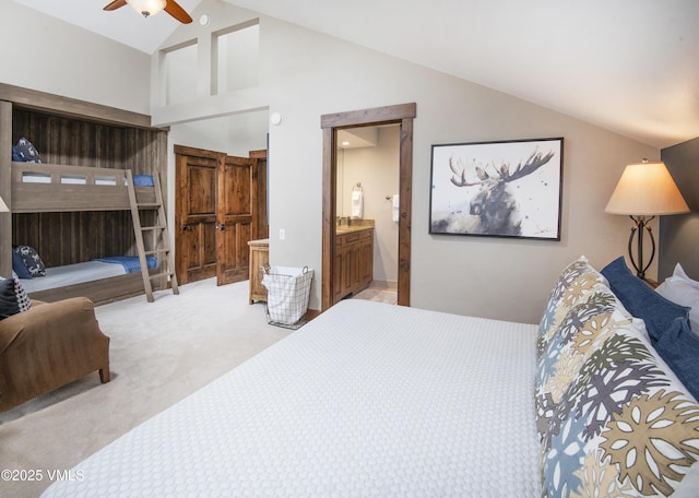 bedroom with ceiling fan, connected bathroom, high vaulted ceiling, and light carpet