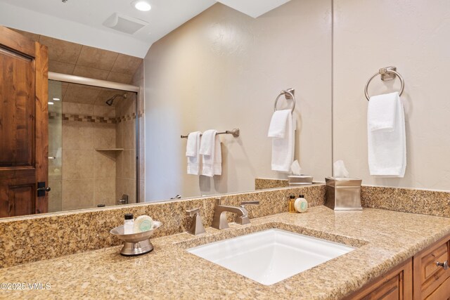 bathroom featuring vanity and a shower with shower door