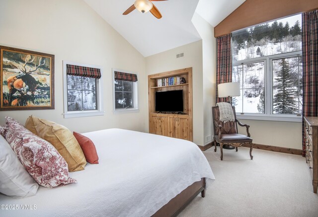 carpeted bedroom with ceiling fan and high vaulted ceiling