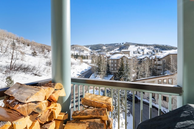 snow covered back of property featuring a mountain view