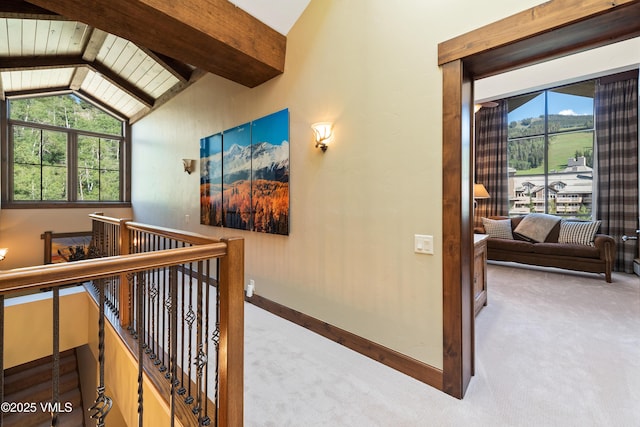 hall featuring carpet floors and vaulted ceiling with beams