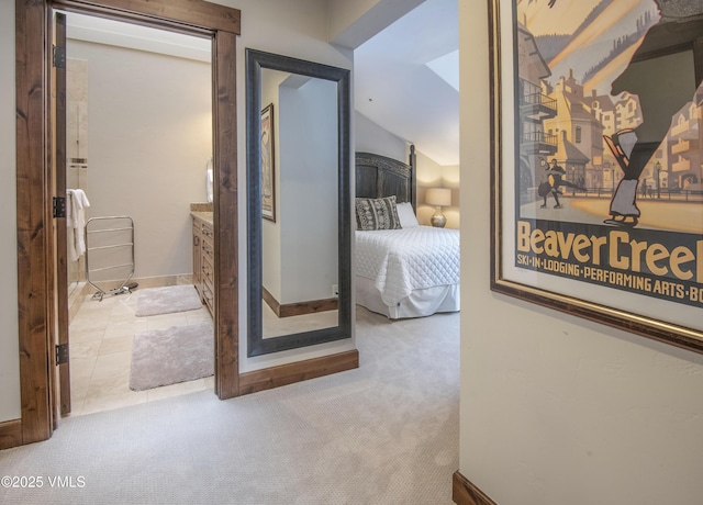 hallway featuring lofted ceiling and light colored carpet