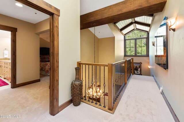 hall featuring a notable chandelier, lofted ceiling with beams, and light colored carpet