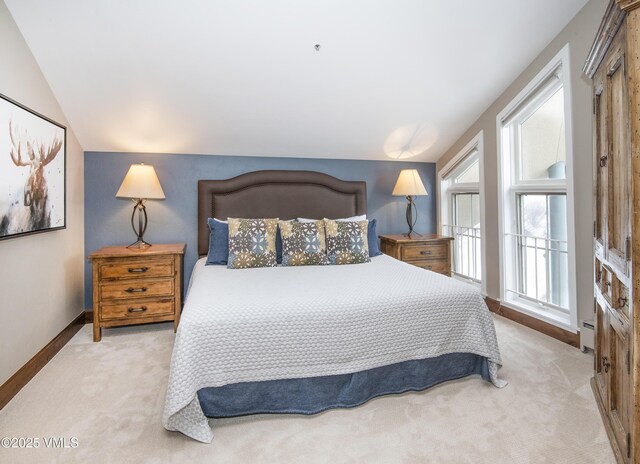 carpeted bedroom featuring a baseboard radiator and lofted ceiling