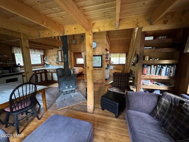 1234 6th St, Eagle, CO 81631 - living area featuring wood walls, a wooden ceiling with exposed beams, hardwood / wood-style flooring, and a wood stove