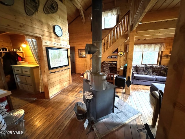 1234 6th St, Eagle, CO 81631 - living area featuring wooden walls, a wood stove, plenty of natural light, hardwood / wood-style flooring, and a wood ceiling with exposed beams