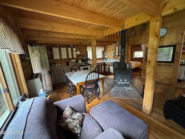 1234 6th St, Eagle, CO 81631 - dining room featuring wooden walls, wood finished floors, a wood ceiling with exposed beams, and a wood stove