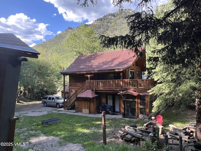 817 Main St, Minturn, CO 81645 - back of house featuring stairs, a deck with mountain view, a metal roof, and a lawn