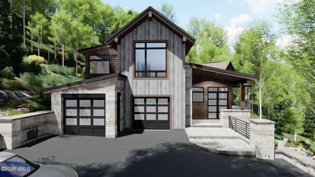 contemporary house featuring stone siding, driveway, and an attached garage