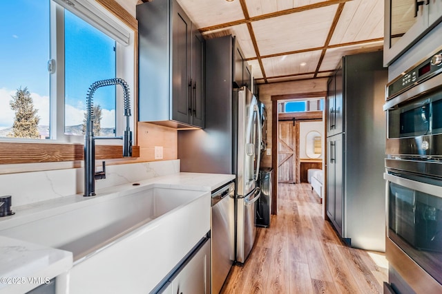 329 River Frontage Rd Unit 18, Silt, CO 81652 - kitchen featuring appliances with stainless steel finishes, a sink, light wood-style flooring, and light stone countertops
