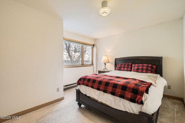 carpeted bedroom featuring baseboards and baseboard heating