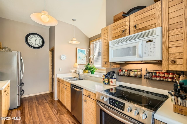 kitchen with lofted ceiling, dark wood-style flooring, a sink, stainless steel appliances, and light countertops