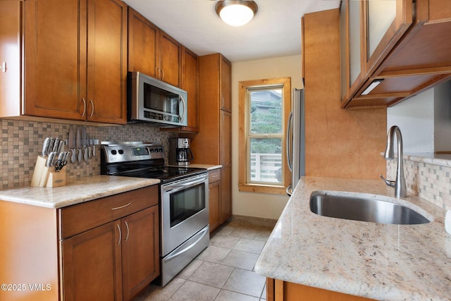 5024 Main Gore Dr S Unit 16, Vail, CO 81657 - kitchen featuring appliances with stainless steel finishes, a sink, decorative backsplash, brown cabinets, and light tile patterned flooring