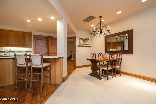 carpeted dining room featuring visible vents, baseboards, stairs, recessed lighting, and a notable chandelier