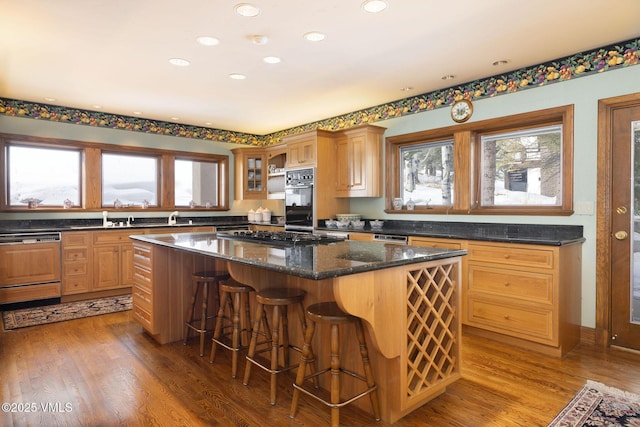 kitchen with plenty of natural light, gas stovetop, light wood-style floors, and a center island