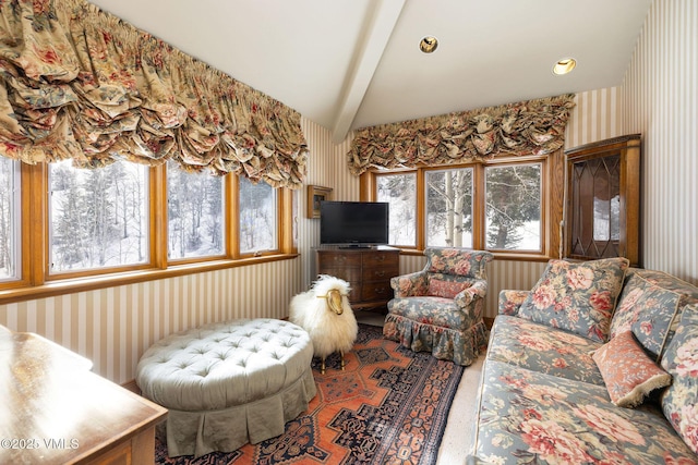 carpeted living area featuring lofted ceiling with beams and wallpapered walls