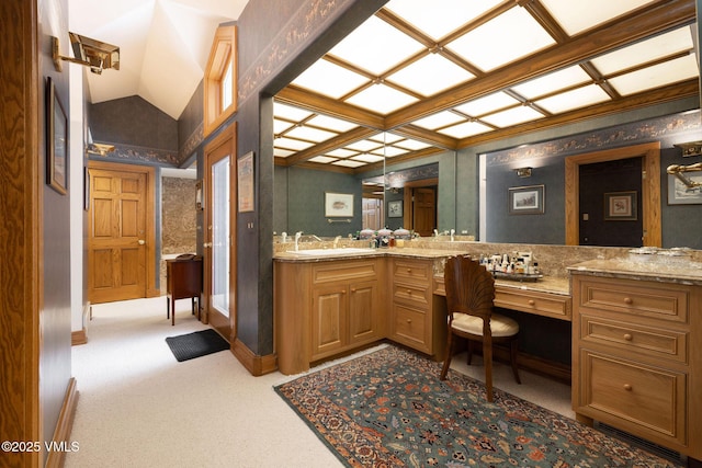 bathroom with vanity, lofted ceiling, and baseboards