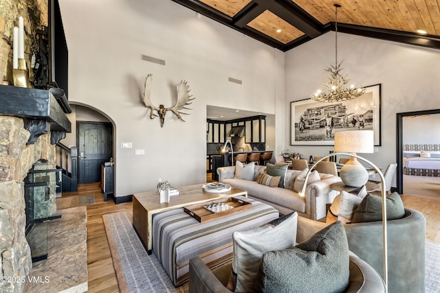 living room with visible vents, beam ceiling, wood finished floors, arched walkways, and high vaulted ceiling