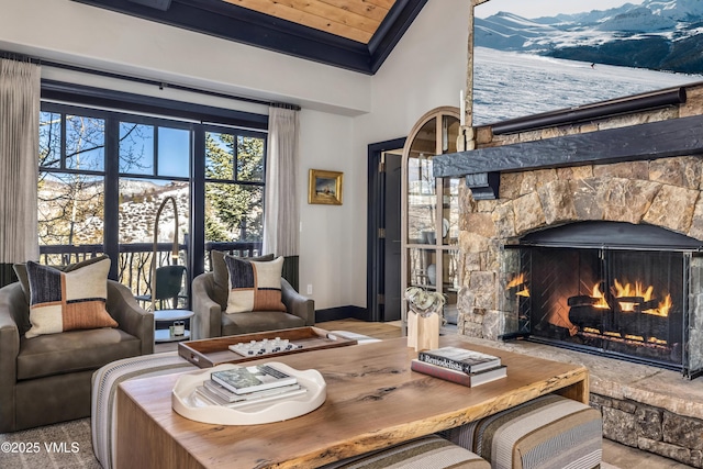 living area with baseboards, a fireplace, and crown molding