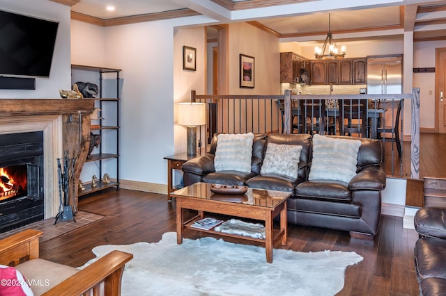 living area with a fireplace with flush hearth, crown molding, hardwood / wood-style floors, and an inviting chandelier