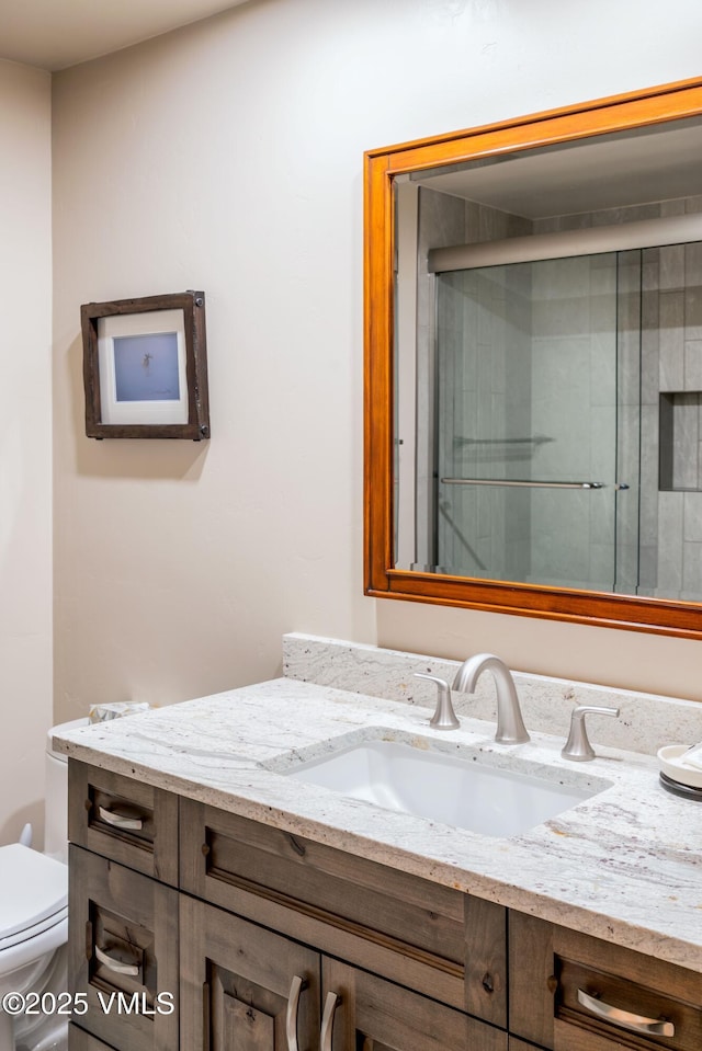 full bathroom with tiled shower, vanity, and toilet