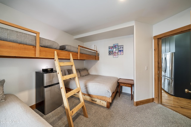 bedroom featuring carpet floors and stainless steel fridge