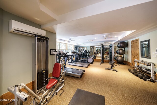 workout area featuring carpet flooring, a wall mounted air conditioner, ceiling fan, and a tray ceiling