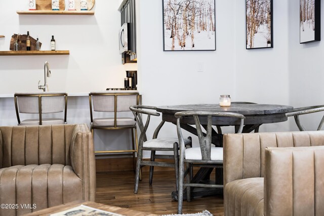 dining area featuring hardwood / wood-style floors and wet bar