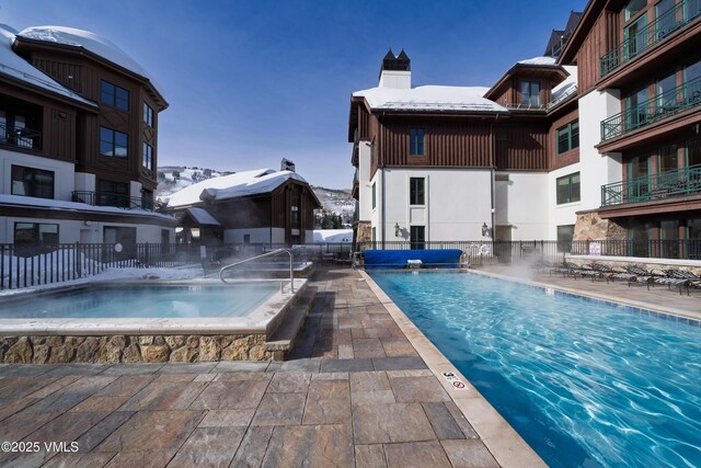 view of swimming pool with a jacuzzi and a patio