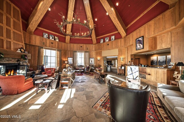 living room with an inviting chandelier, wood ceiling, wooden walls, and beamed ceiling