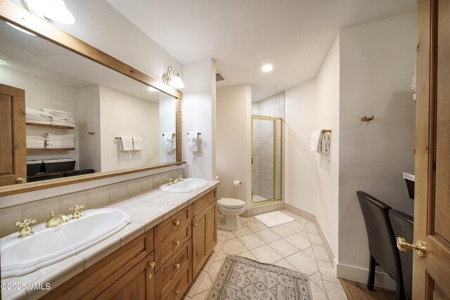 bathroom featuring vanity, toilet, tile patterned flooring, and a shower with door