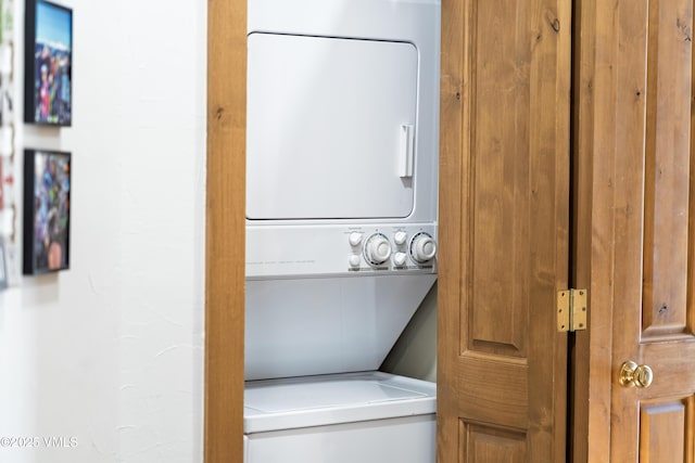 clothes washing area featuring stacked washing maching and dryer