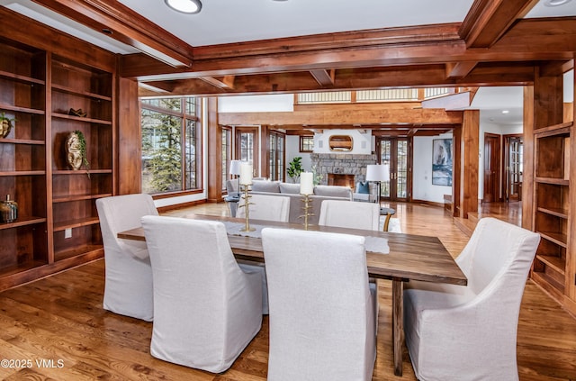 460 El Mirador Rd, Edwards, CO 81632 - dining space featuring a stone fireplace, wood finished floors, crown molding, beamed ceiling, and wooden walls