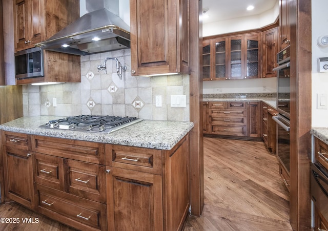 460 El Mirador Rd, Edwards, CO 81632 - kitchen featuring island range hood, appliances with stainless steel finishes, wood finished floors, and glass insert cabinets