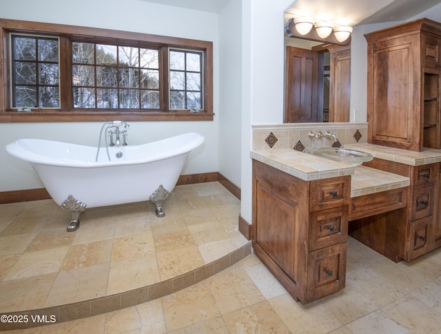 460 El Mirador Rd, Edwards, CO 81632 - bathroom with baseboards, vanity, a freestanding bath, and decorative backsplash