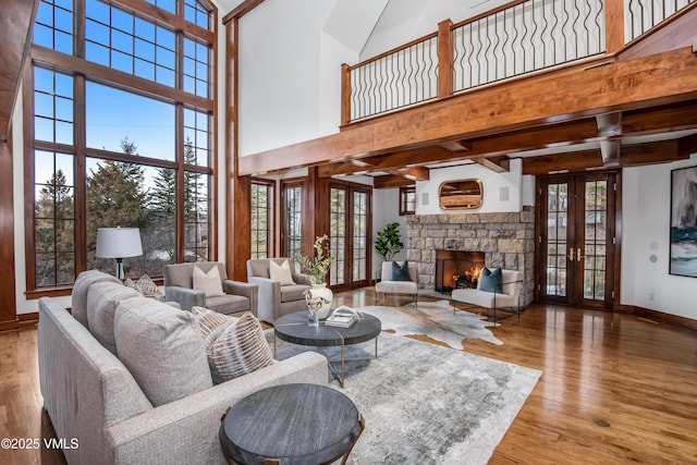 460 El Mirador Rd, Edwards, CO 81632 - living area featuring french doors, a high ceiling, wood finished floors, baseboards, and a stone fireplace