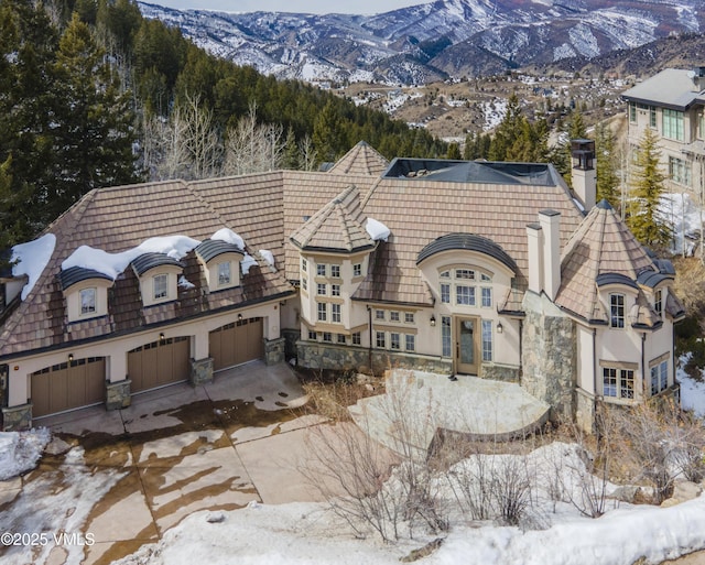 460 El Mirador Rd, Edwards, CO 81632 - french country inspired facade featuring stone siding, a garage, a mountain view, and concrete driveway