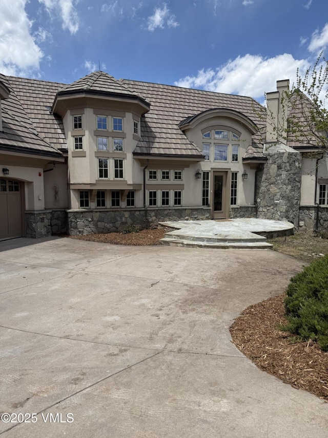 460 El Mirador Rd, Edwards, CO 81632 - rear view of property with stucco siding, stone siding, and driveway