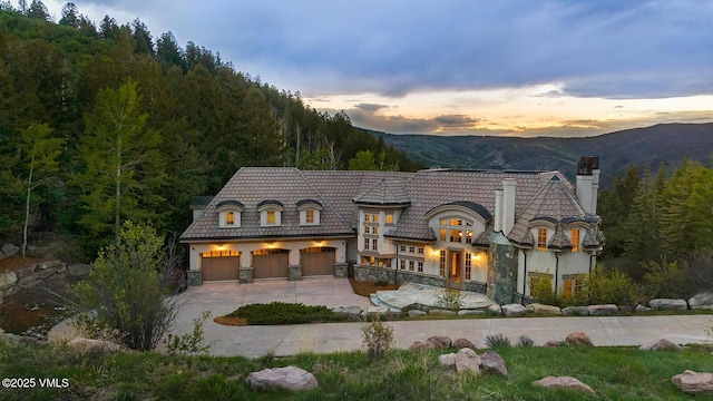 460 El Mirador Rd, Edwards, CO 81632 - rear view of house with a chimney, driveway, a mountain view, a forest view, and stucco siding
