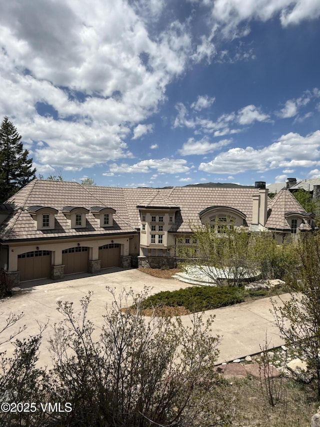 460 El Mirador Rd, Edwards, CO 81632 - french country home featuring concrete driveway, stone siding, an attached garage, and stucco siding