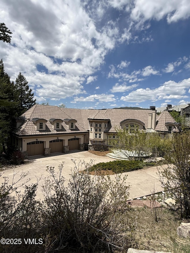 460 El Mirador Rd, Edwards, CO 81632 - french provincial home featuring concrete driveway, an attached garage, stone siding, and stucco siding