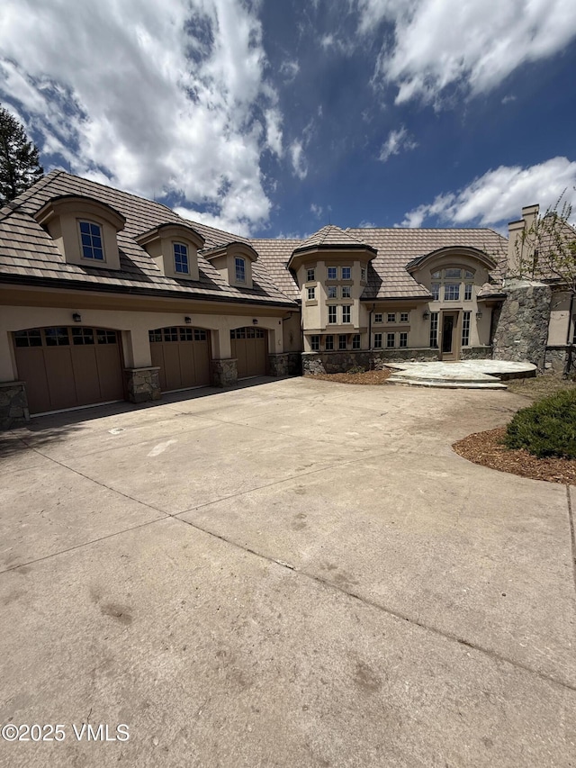 460 El Mirador Rd, Edwards, CO 81632 - view of front facade with stucco siding, stone siding, concrete driveway, and an attached garage