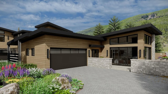 view of front facade featuring a garage, a mountain view, and decorative driveway