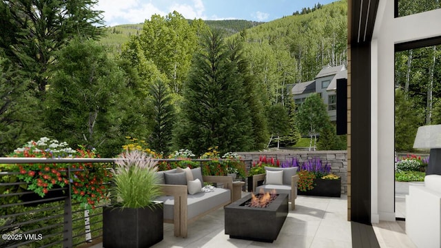 view of patio with a wooded view and an outdoor living space with a fire pit